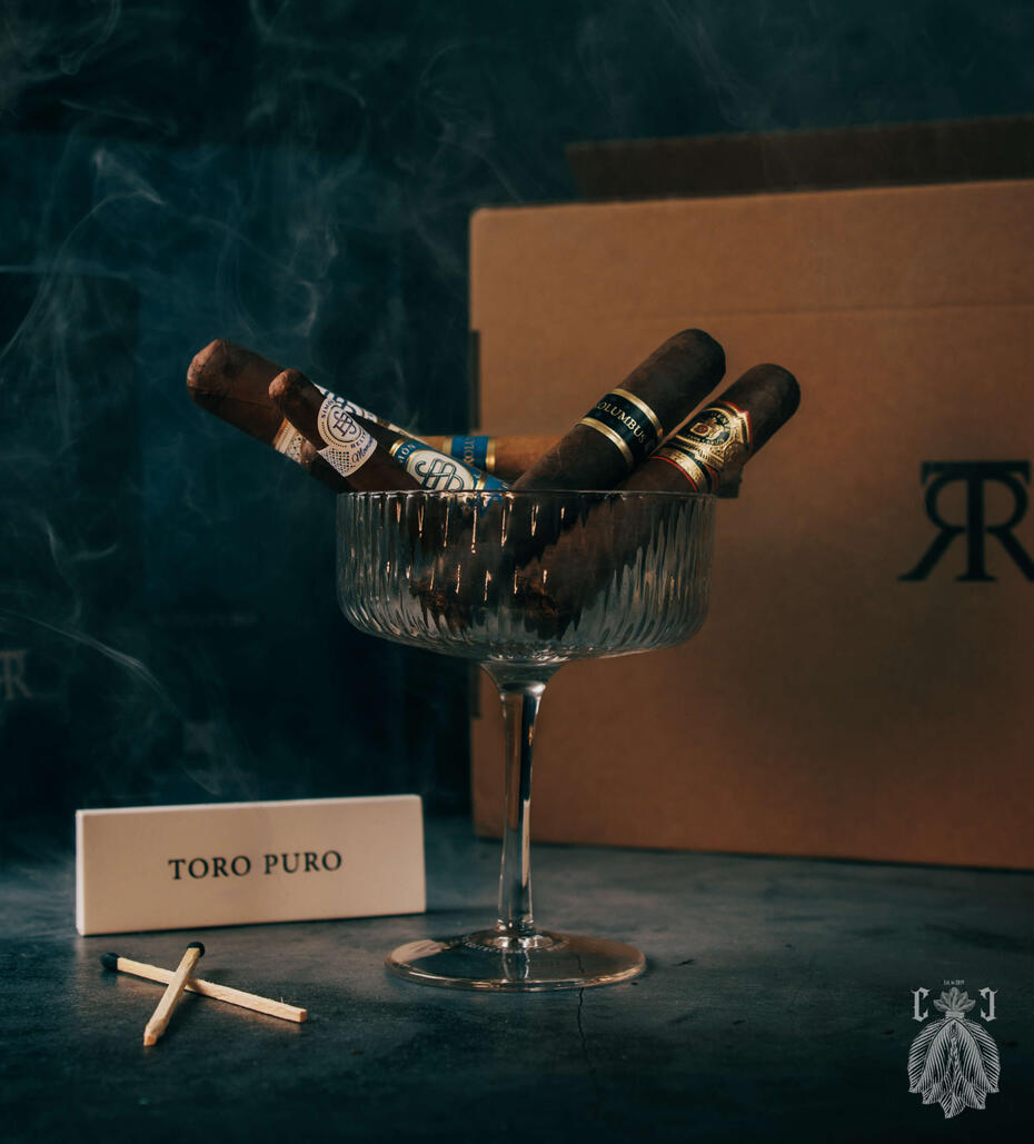 premium cigars in a glass with Toro Puro matches next to them